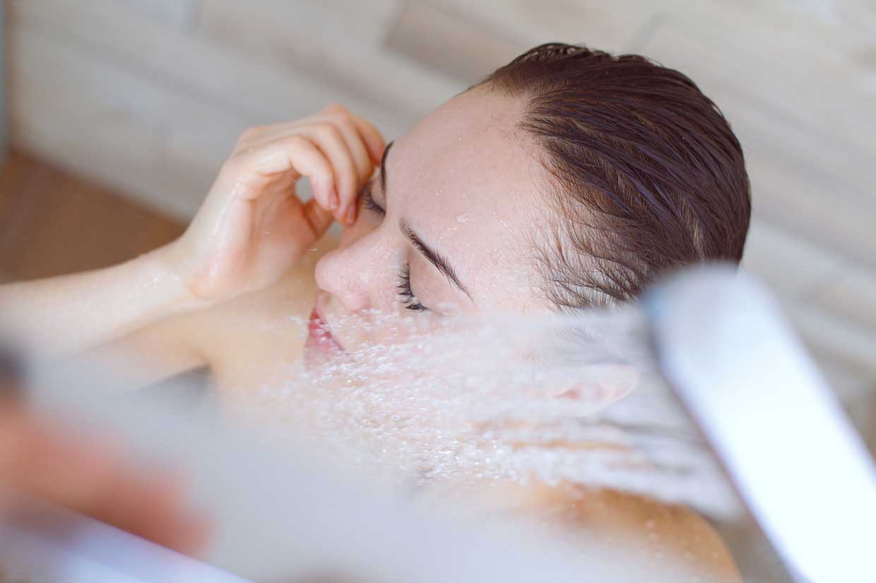 Young beautyful woman under shower in bathroom. Kąpiel sposobem na lepszą odporność